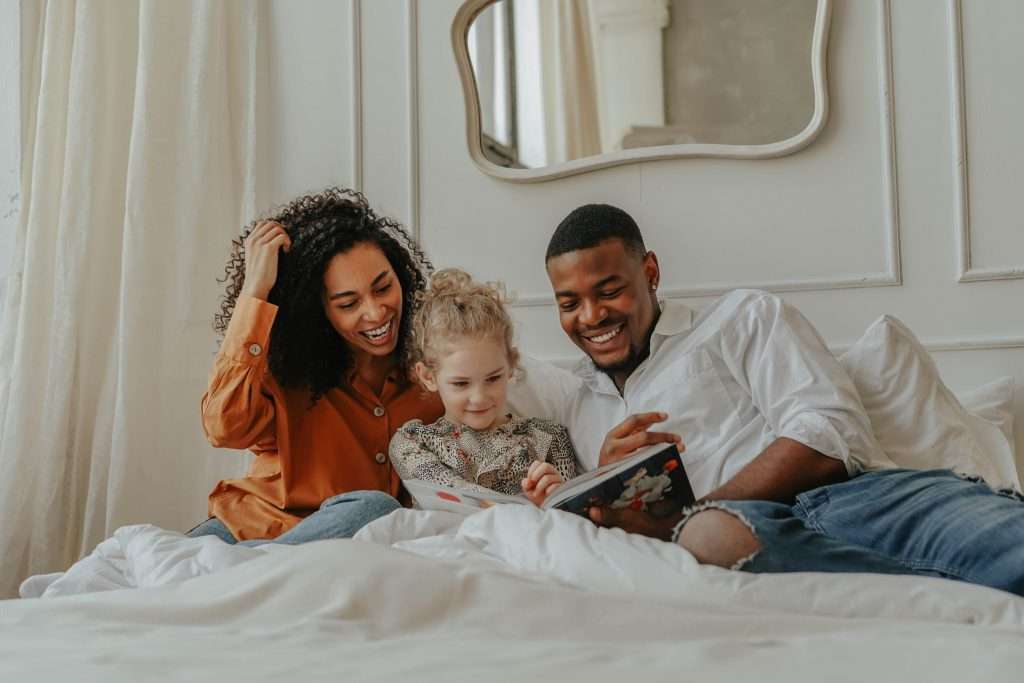 Parents reading and spending time with their daugther