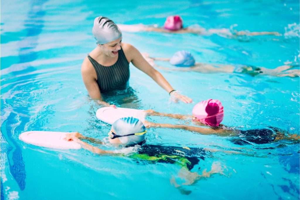 Mom Encouraging kid to swim in the swimming pool