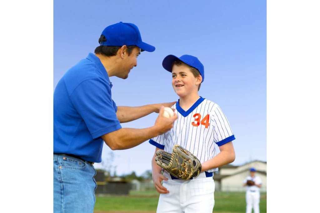 Dad encouraging his son in baseball match