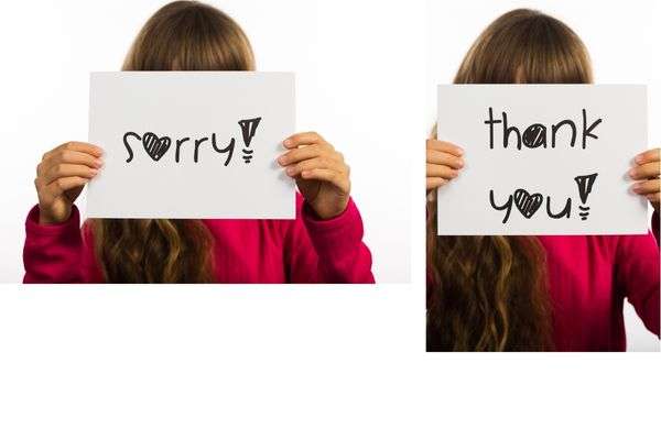 Kid holding Thank You and Sorry placards